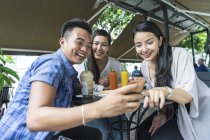 Young beautiful asian friends taking selfie in cafe — Stock Photo