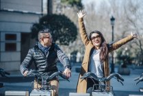 Chinese couple in Madrid riding a bicycles, Spain — Stock Photo