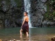 Привлекательная азиатская молодая женщина отдыхает у водопада в Таиланде — стоковое фото