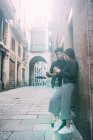 Молода азіатська пара має каву на вулиці і дивиться на мобільний телефон — стокове фото