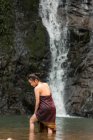Attractive asian young woman relaxing near waterfall in Thailand — Stock Photo