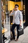 Chinesischer Geschäftsmann telefoniert auf der Straße neben einem Luxusladen in der serrano street, madrid, spanien — Stockfoto