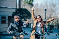 Pareja china en Madrid montando en bicicleta - foto de stock