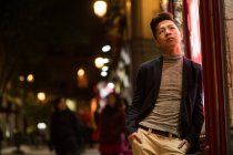 Lässiger junger Chinese, der nachts in den Straßen Madrids herumhängt, Spanien — Stockfoto
