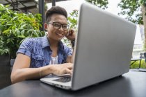 Филиппинский человек, работающий над ноутбуком в кафе — стоковое фото