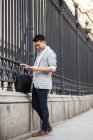 Китайський бізнесмен текстові повідомлення на телефон на вулиці в Мадриді, Іспанія — стокове фото