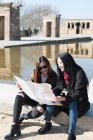 Asian women doing tourism in Madrid and looking at a city map, Spain — Stock Photo