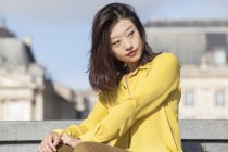 Jeune femme chinoise posant et détournant les yeux — Photo de stock