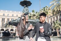 Happy young asian tourist couple drinking coffee in Barcelona and listening music, spain — Stock Photo