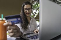 Jeune belle asiatique femme faire transaction avec ordinateur portable — Photo de stock