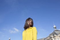 Giovane donna con i capelli che coprono il viso contro il cielo blu — Foto stock