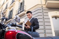 Hombre de negocios chino leyendo en la calle - foto de stock