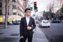 Porträt eines smarten chinesischen Geschäftsmannes, der in der Serrano-Straße in Madrid, Spanien steht — Stockfoto