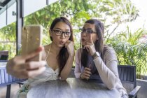 Jovem atraente asiático mulheres tomando selfie no café — Fotografia de Stock