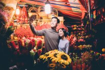 Feliz asiático pareja celebrando chino año nuevo en ciudad y tomando selfie - foto de stock