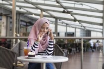 Молода жінка Дрочить деяку інформацію в кафе — стокове фото