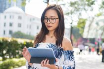 Jolie fille asiatique avec tablette dans la rue — Photo de stock