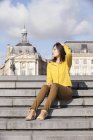 Молодая женщина сидит на лестнице в Париже, Франция — стоковое фото