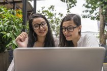 Jovem bonito asiático mulheres partilha laptop juntos — Fotografia de Stock