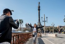 Pareja de turistas jóvenes tomando fotos en el monumento de Colón con - foto de stock