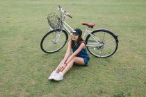 Mujer joven que se relaja con su bicicleta en Japón - foto de stock