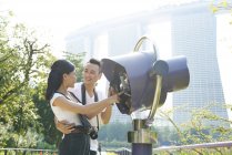 Lovely couple using the electronic binoculars at Gardens by the Bay — Stock Photo