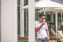 Man with sunglasses having drink in hotel — Stock Photo