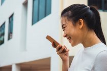 Junge attraktive asiatische Frau mit Smartphone — Stockfoto