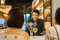 Giovani amici asiatici in confortevole bar — Foto stock