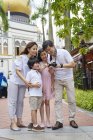Familia revisando las imágenes que tomaron en Arab Street, Singapur - foto de stock