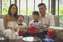 Счастливая семья из четырех человек празднует Рождество в своем доме в Сингапуре . — стоковое фото