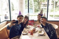 Felici giovani amici asiatici che celebrano il Natale insieme nel caffè e scattare selfie — Foto stock