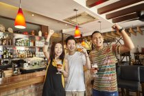 Happy young asian friends together in bar — Stock Photo