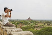 Jovem tirando fotos em Shwesandw Pagoda, Bagan, Mianmar — Fotografia de Stock