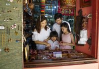 Happy young asian family together at street market — Stock Photo