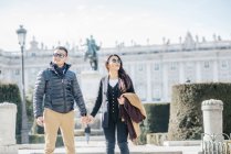Chinesse couple walking around la almudena ana palacio real in Madrid, Spain — Stock Photo