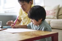 Glücklich junge asiatische Familie zusammen zeichnen zu Hause — Stockfoto