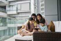 Щаслива молода азіатська сім'я разом використовує ноутбук вдома — стокове фото