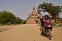 Jeune homme en moto à la pagode, Myanmar — Photo de stock