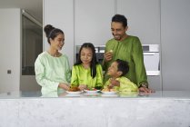 Joven asiático familia celebrando hari raya juntos en casa - foto de stock