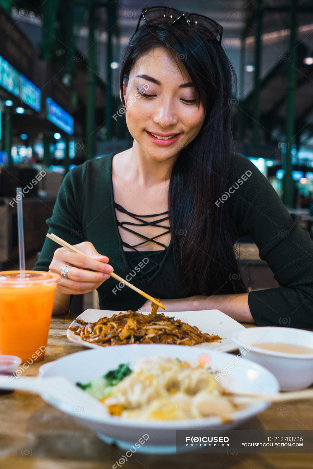 Young Asian Woman Eating Food With Chopsticks — Chilling Attractive