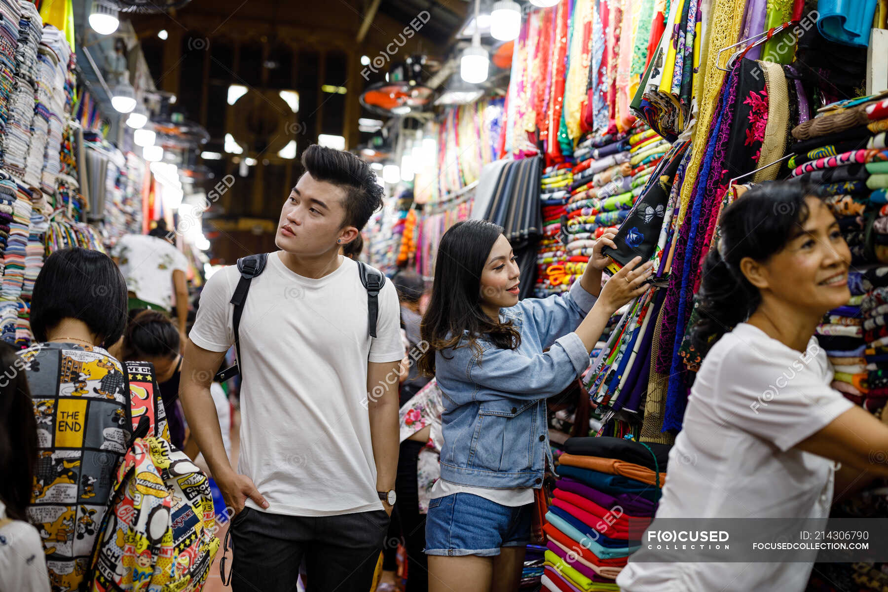 Young Vietnamese couple looking clothes a market in Saigon, Vietnam ...