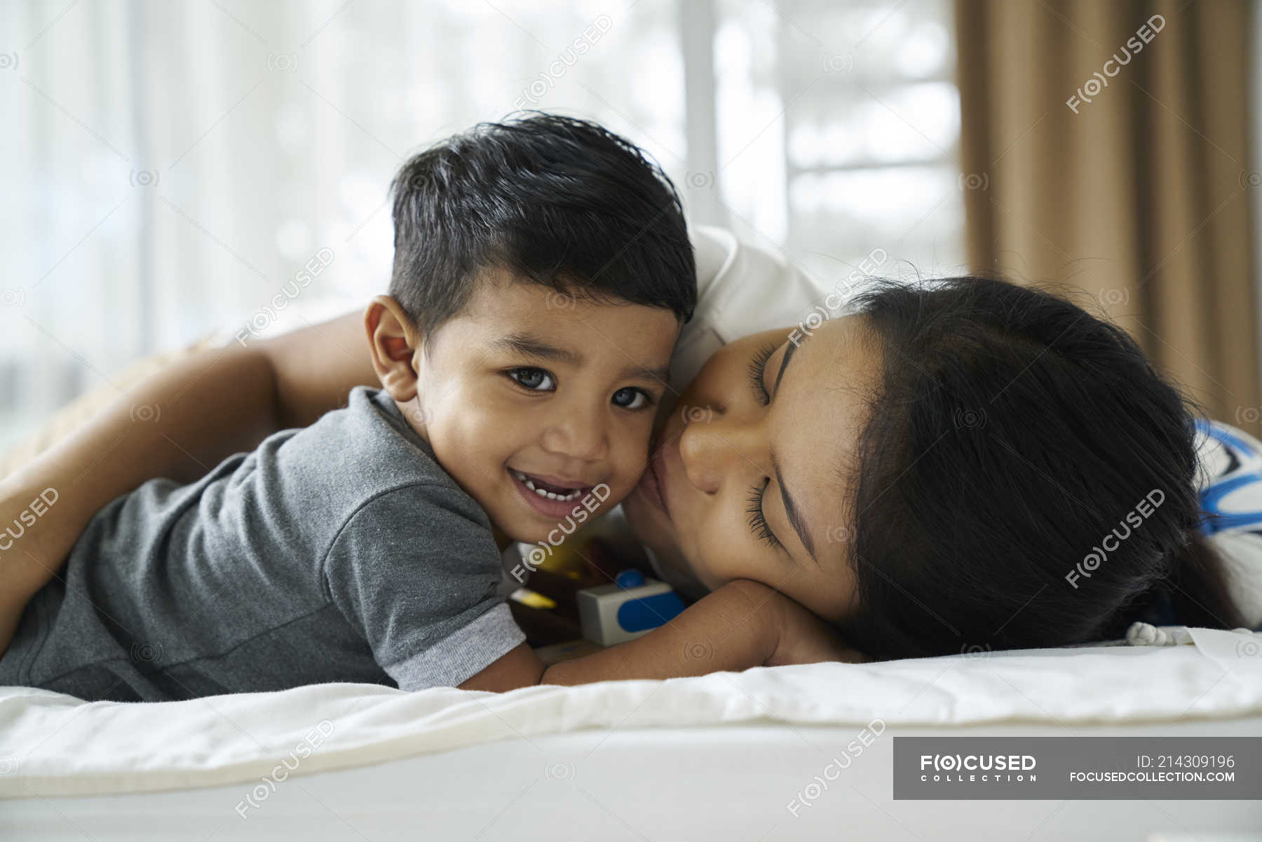 Asian mother bonding with her son on the bed — affection, room - Stock ...