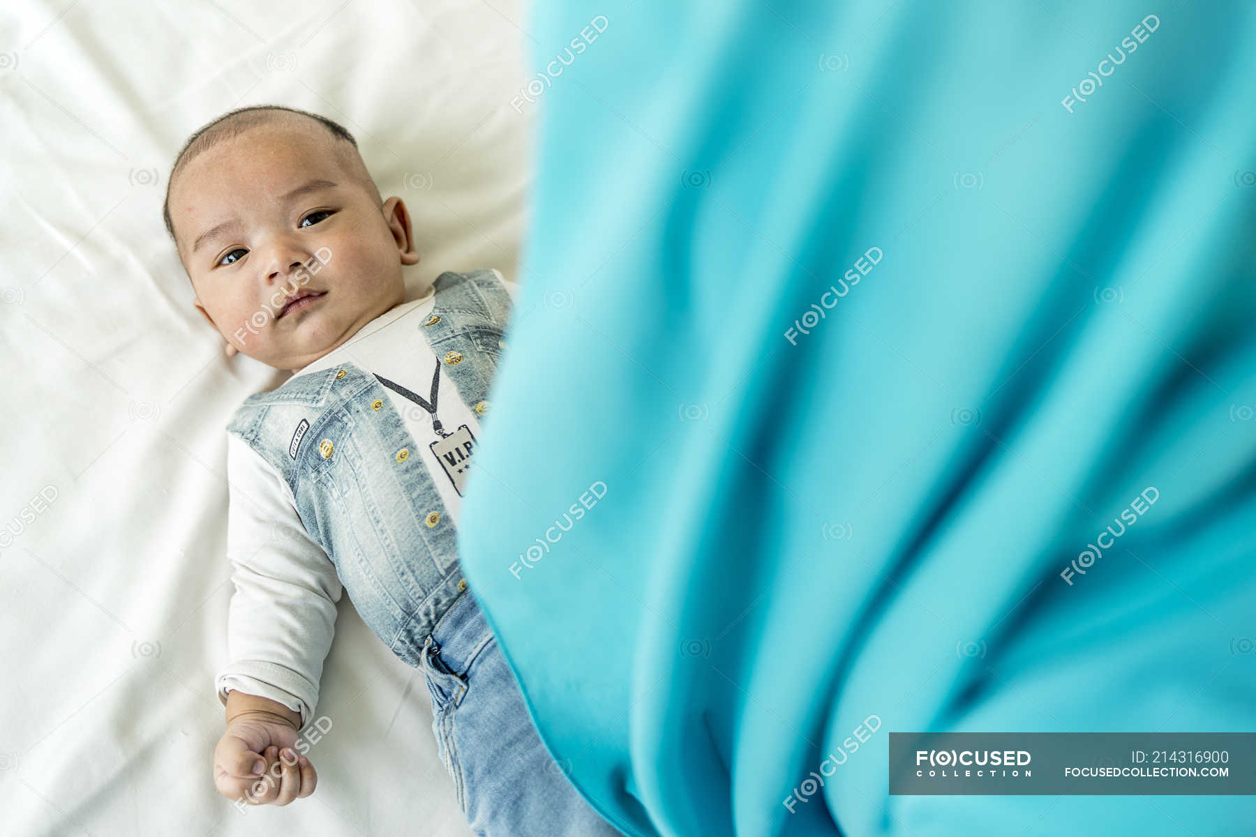 baby-lying-down-on-the-bed-looking-at-the-camera-three-quarters