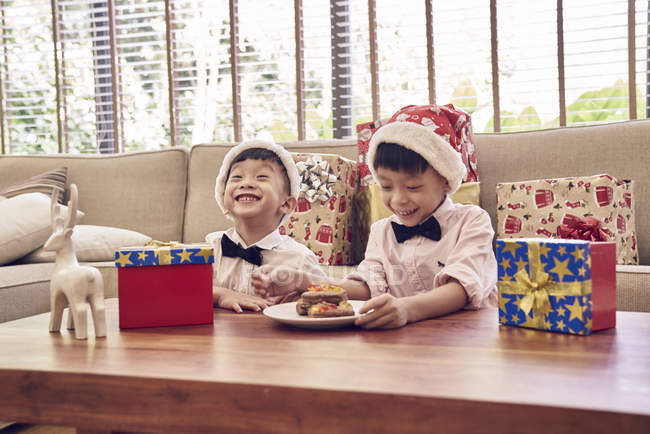 Feliz asiático hermanos celebrando Navidad juntos - foto de stock