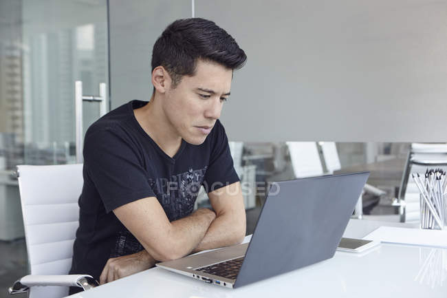 Красивий азіатський бізнесмен працює з ноутбуком в офісі — стокове фото