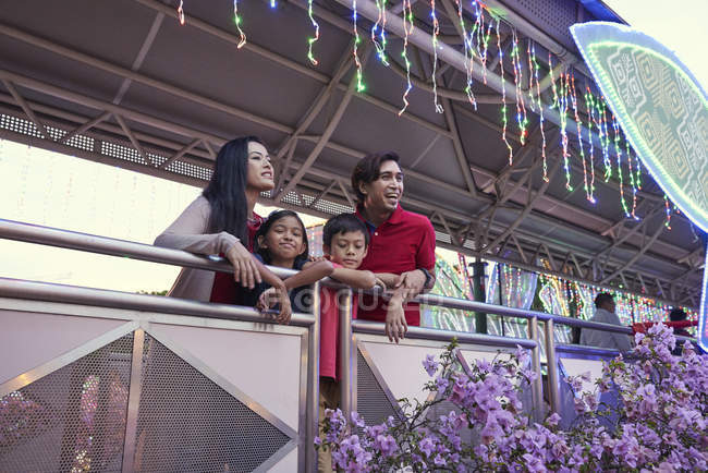Familia feliz comprobando la luz en Geylang Hari Raya Bazaar, Singapur - foto de stock