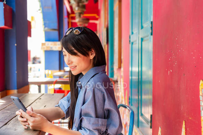 Atractivo adulto asiático mujer usando smartphone - foto de stock