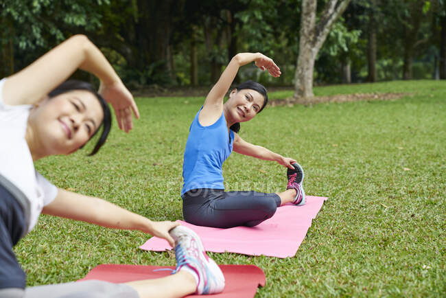 Zwei Frauen praktizieren Yoga im Botanischen Garten in Singapur — Stockfoto