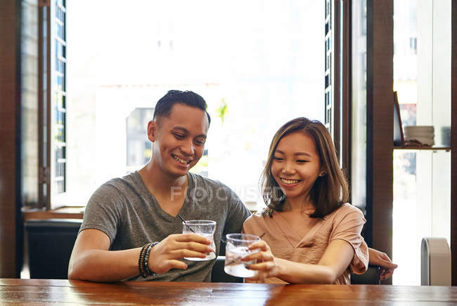 Young asian couple drinking at restaurant — Stock Photo